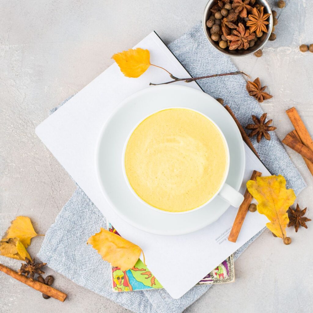 golden turmeric latte with spices on table
