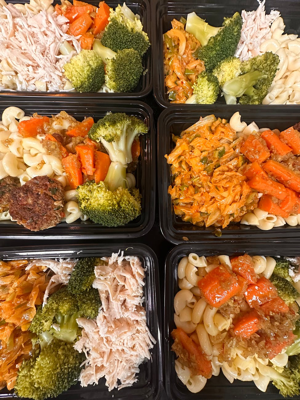healthy meal prep trays with pasta and vegetables