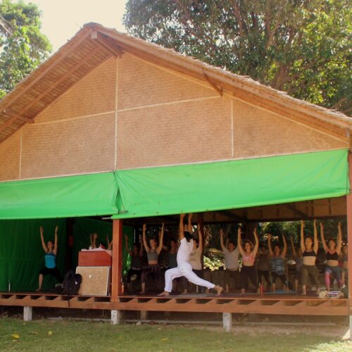 people practicing yoga in a nipa hut