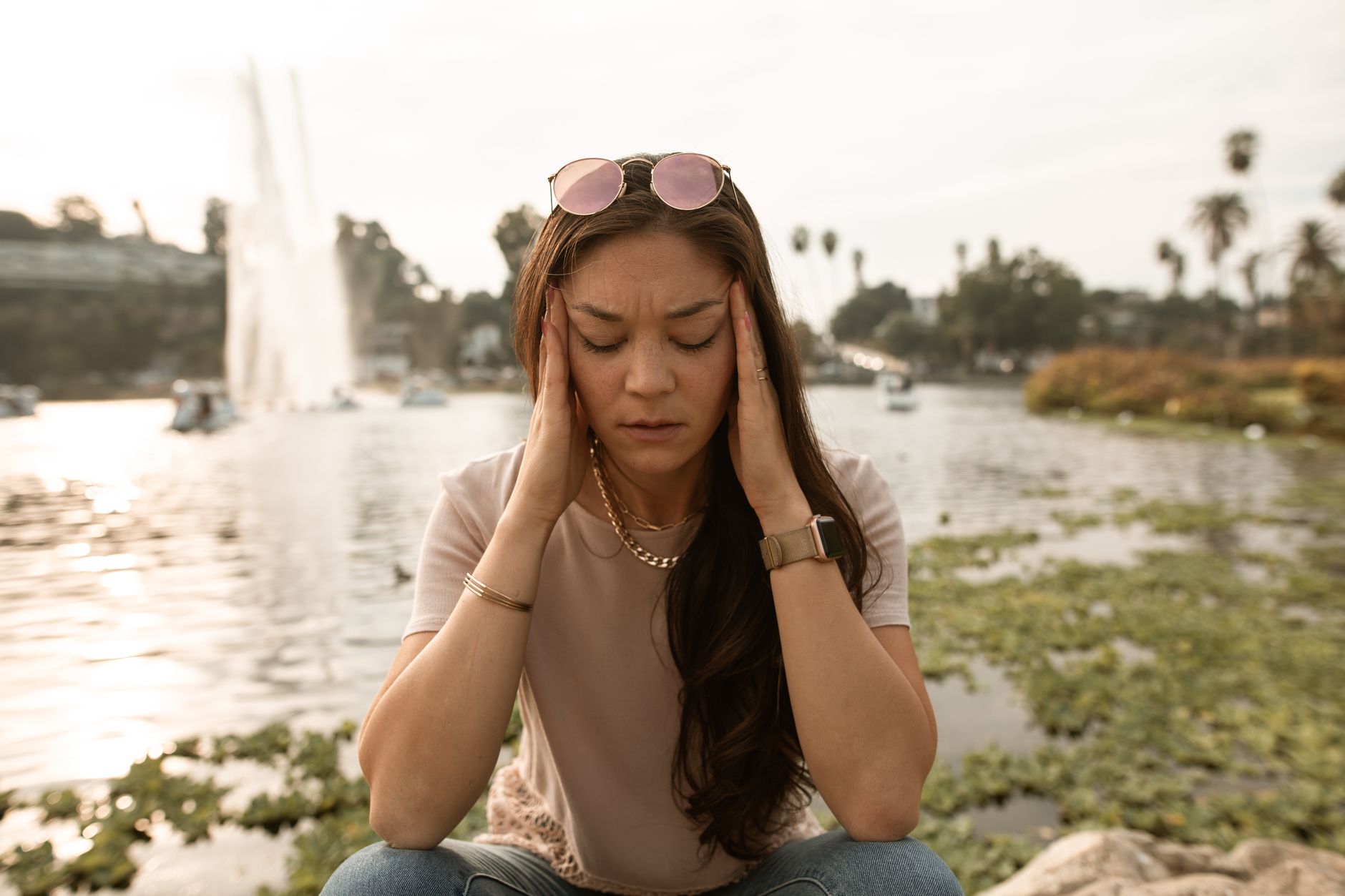 a woman sitting beside a lake